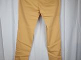 a pair of yellow pants hanging on a white curtain