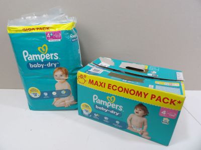 deux boîtes de couches pour bébé posées sur une table à côté d'une boîte de couches