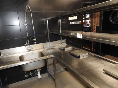 une cuisine avec des plans de travail en inox et un évier