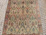 un tapis persan ancien posé sur un sol pavé