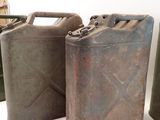three old gas cans sitting next to each other on a table