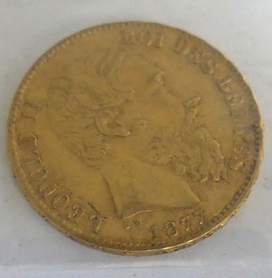 a close up of a gold coin on a white surface