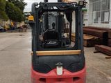 a red forklift truck parked in a parking lot
