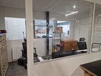 une pièce avec un bureau, une chaise et une grande fenêtre