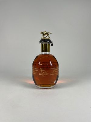 gros plan d'un flacon de parfum sur une surface blanche