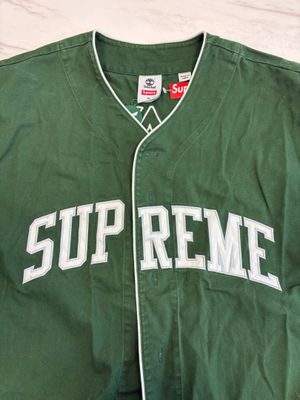 green supreme baseball jacket with white letters on the front