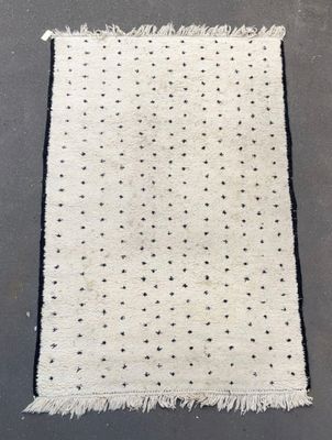 un tapis blanc à pois noirs et à franges