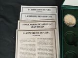 several different coins are in a green box on a table