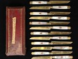 several knives are lined up in a row next to a red box