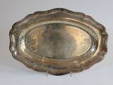 a silver tray with a silver handle on a white surface