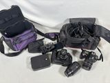 plusieurs appareils photo et un sac pour appareil photo posés sur une surface blanche