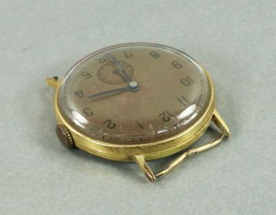 une montre en or posée sur une table blanche