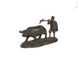 figurine en bronze représentant un homme labourant avec un taureau à l'aide d'un marteau