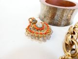 un bol en argent et un bracelet en or posés sur une table blanche