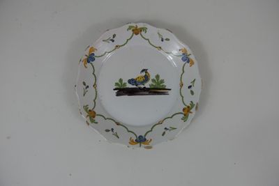 une assiette sur laquelle est représenté un oiseau, accrochée au mur