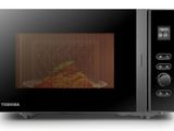 un micro-ondes noir contenant une assiette de nourriture