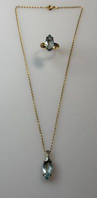 a gold necklace with a blue topaz stone and a gold chain