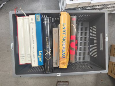 many books in a plastic box on the floor