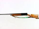 the rifle is laying on a white surface with a green cord
