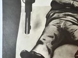 a black and white poster of a man holding a gun