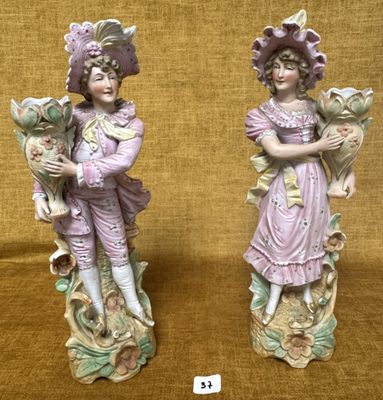 une paire de figurines représentant un garçon et une fille tenant des fleurs