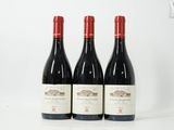 trois bouteilles de vin rouge sont alignées sur une surface blanche