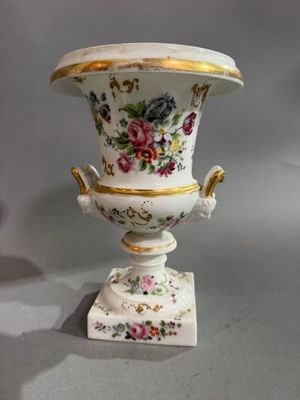 un vase posé sur un support sur une table