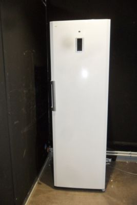 a white refrigerator in a room with a black wall