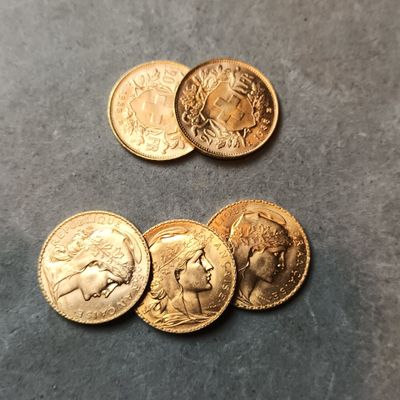 quatre types différents de pièces d'or posées sur une table
