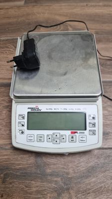 a digital scale with a mouse on top of it