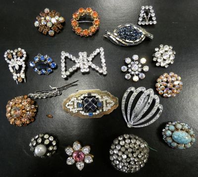 many different types of brooches on a black surface