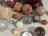 tout un tas de boules en verre de toutes sortes posées sur une table