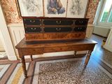 a wooden table with two drawers and a painting on the wall
