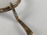 an antique silver plated magnifying glass with a spoon on it