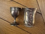 deux gobelets en argent posés sur une table en bois