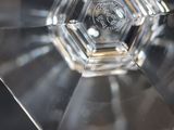 someone is holding a clear glass object in their hand