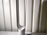 a white fan sitting on a table next to a wall