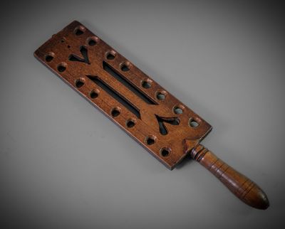 an old wooden tool with holes and holes on it