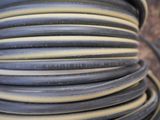 a close up of a spool of black and yellow hoses