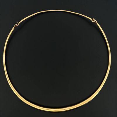 a gold choke necklace with a curved design