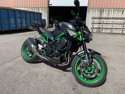 a black and green motorcycle parked in front of a building