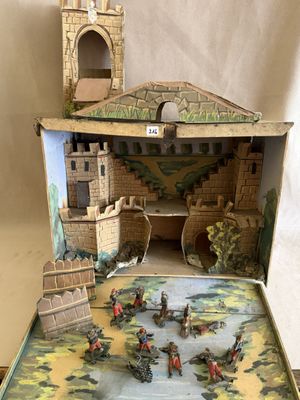une petite maquette de château dans une boîte posée sur une table