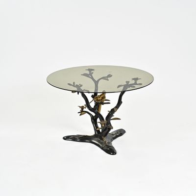 une table en verre sur laquelle se trouve un oiseau, sur fond blanc
