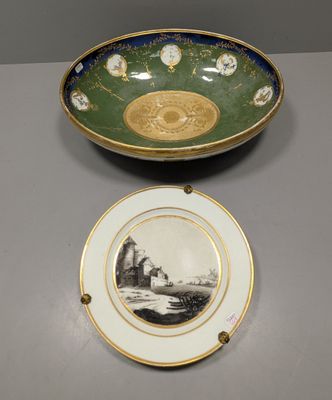 une assiette verte et dorée sur laquelle est représenté un château