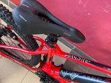 a red bike with a black seat sitting on the floor