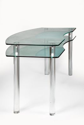 deux tables en verre transparent posées l'une sur l'autre sur une surface blanche