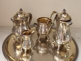 a silver tray with a silver tea set on it