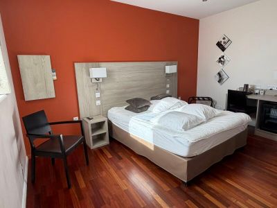 hardwood flooring in a hotel room with a bed, desk and chair