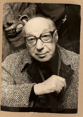 photographie en noir et blanc d'un homme portant des lunettes et une veste