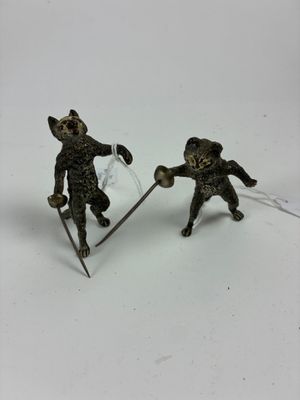 deux figurines représentant deux chats à skis sur une surface blanche